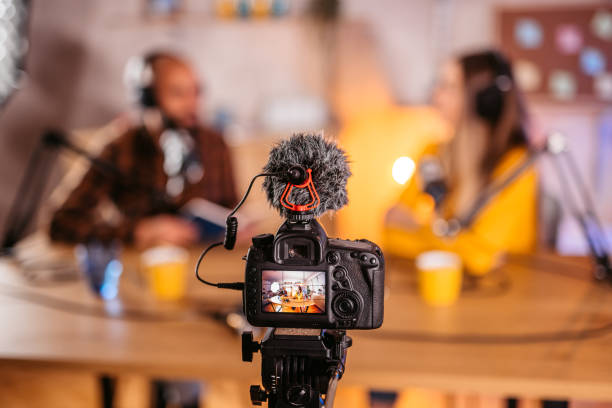 istock Two hosts in headphones recording podcast in broadcasting 1358952127