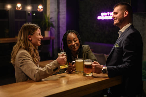 istock Cheerful colleagues drinking beer in the bar together after work and using a tablet 1358952636