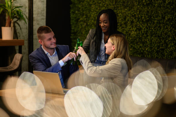 istock Colleagues working on a laptop and having a meeting in a cafe while toasting 1358952643