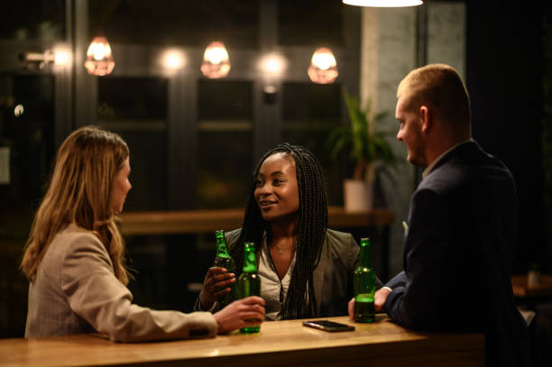 istock Cheerful colleagues drinking beer in the bar together after work 1358952649