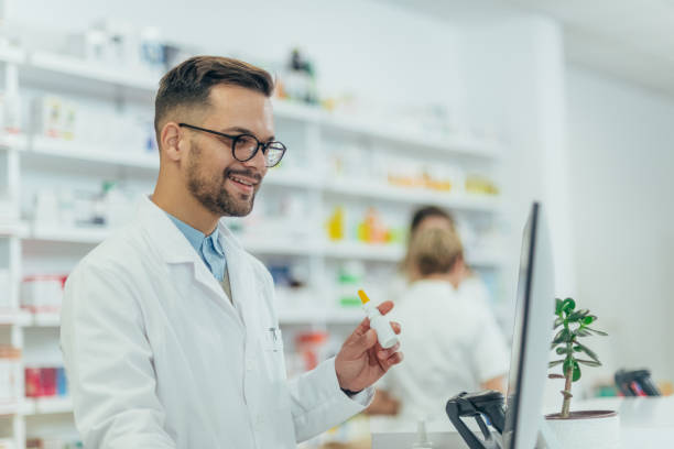 istock Male pharmacist holding nose spray while working at a pharmacy 1358952666