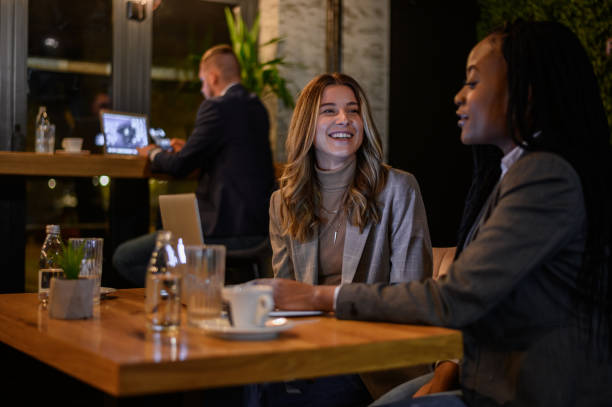 istock Two businesswoman having a meeting in a cafe while using a laptop 1358952674