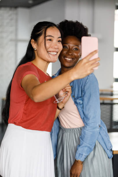 istock Two beautiful young women taking selfies together 1358952731