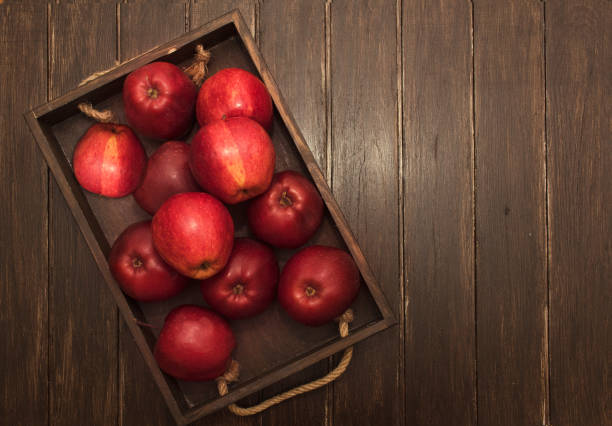 istock Ripe red apples in wooden box. Top view 1358953580