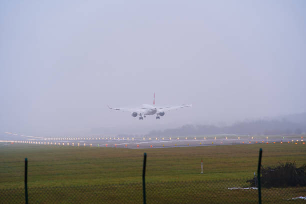 Swiss airplane landing at Zürich Airport on a foggy winter day. Photo taken December 12th, 2021, Zurich, Switzerland.