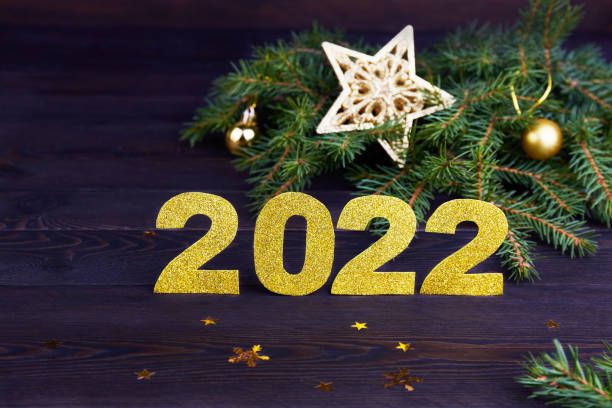 istock Fir branches, golden numbers 2022 , alarm clock on dark wooden background. 1358956321