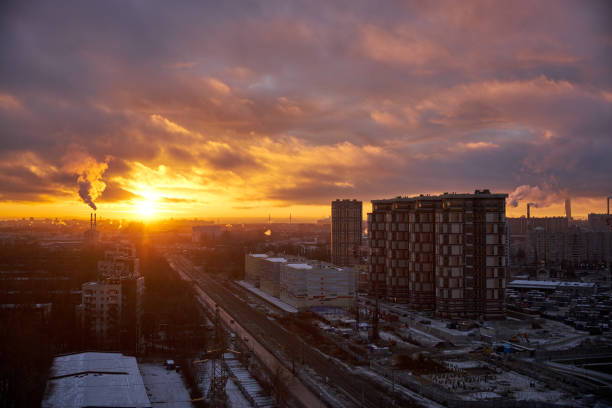 coucher de soleil urbain depuis le toit avec une voie ferrée et une tour et un ciel de coucher de soleil magnifiquement coloré - factory night skyline sky photos et images de collection