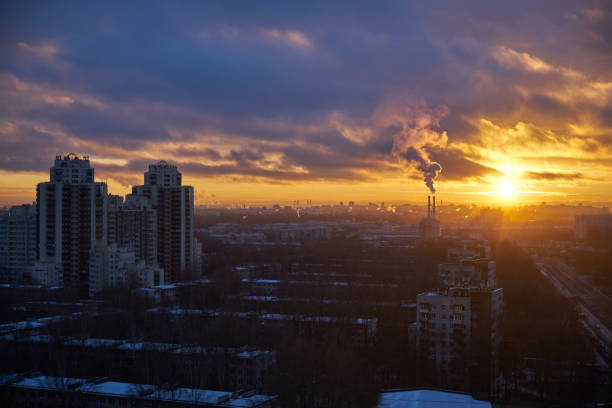 paysage urbain en hiver coucher de soleil depuis la vue aérienne sur un salon d’une grande ville avec des tours résidentielles et un beau ciel coloré nuageux - factory night skyline sky photos et images de collection