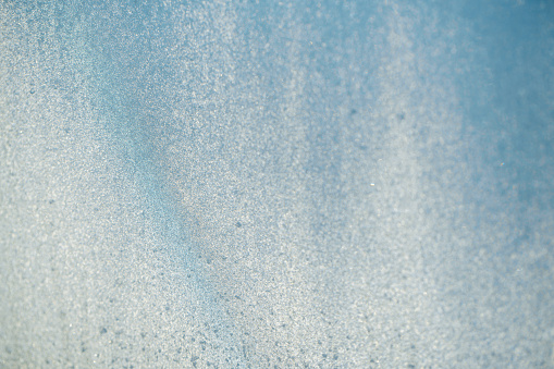 Abstract blue background, looking like a frozen glass in a low temperatures in winter