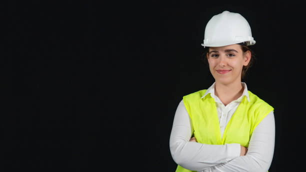 istock She is a young and talented architect, an engineer working in a working area. She looks pretty confident and pleasant in this portrait of herself. She is wearing safety clothes. The concept of this photo is powerful women, strong modern women. 1358961624