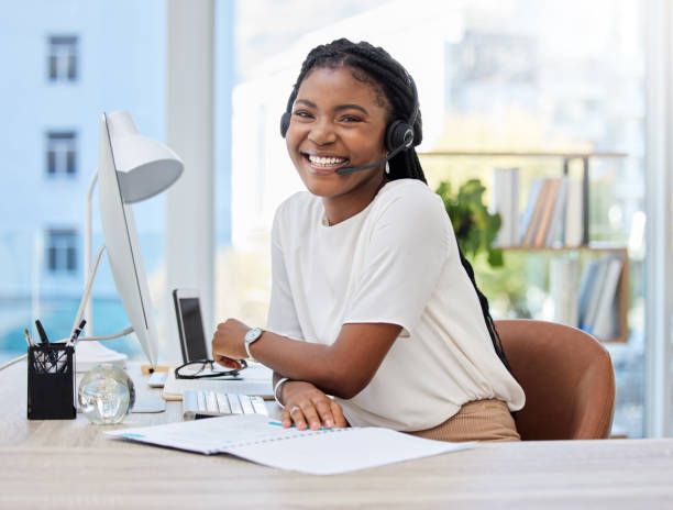 tiro de uma jovem agente de call center usando um computador no trabalho - secretária mobília - fotografias e filmes do acervo