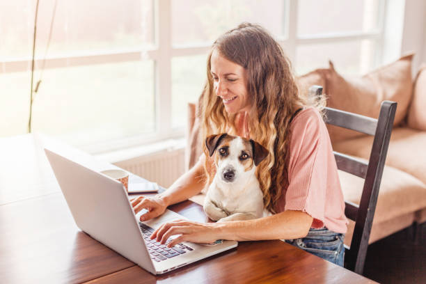istock Female Working On Laptop With Cute Dog 1358963691