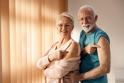 Vacunación viral e inmunización durante el covid 19. Una feliz pareja de ancianos mostrando sus brazos después de la vacuna covid 19 con yesos adhesivos. photo