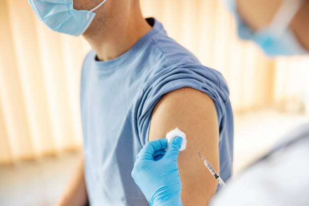 global vaccination and immunization during covid 19. close up of nurse's hands putting an injection of covid 19 vaccine into a patient's arm. - injecting flu virus cold and flu doctors office imagens e fotografias de stock