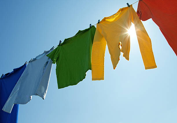 Colorful clothes on a laundry line and sun shining stock photo