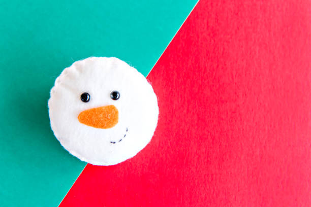 istock snowman on green and red christmas background. 1358968341