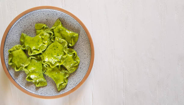 istock Green dumplings with cottage cheese and spinach on ceramic plate on white background 1358968920