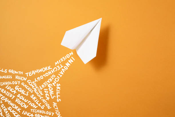 istock Paper Airplane on Orange Background 1358970465