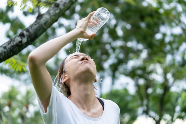 istock Asian girl take a break drink water from bottle after running exercise. Active young athlete sport woman pour water to rinse her face from sweat after workout for health care in evening in public park 1358970499