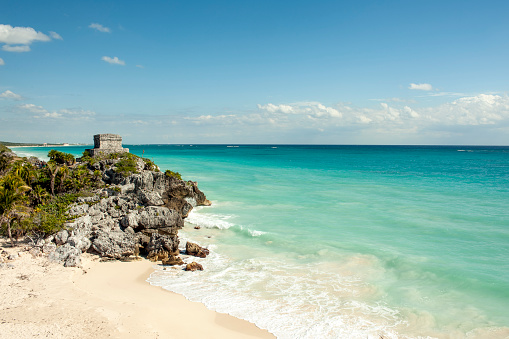 Elevated view of Tulum Beach on a sunny day with Mayan ruin.