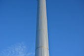 metal tower of reservoir clad with sheet metal aluminum cladding. rivets and corrugated sheets resemble a spaceship, or an alien UFO civilization. silver metallic shiny column and conical water tank