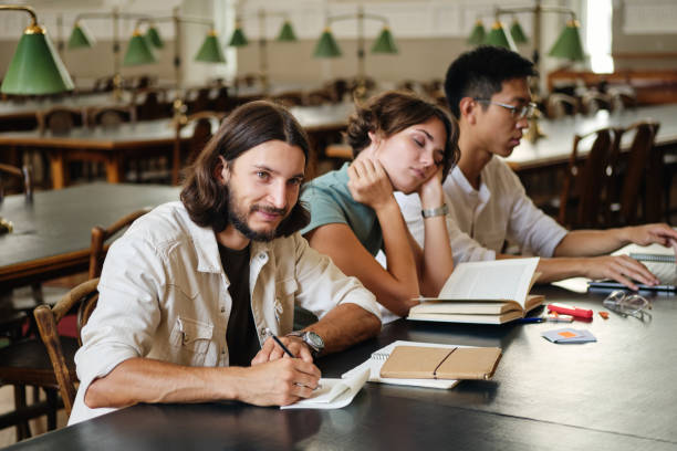 istock Group of young multinational students studying together in library of university 1358971853