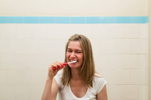 istock Lifestyle scene of brushing teeth looking in the mirror. 1358973055