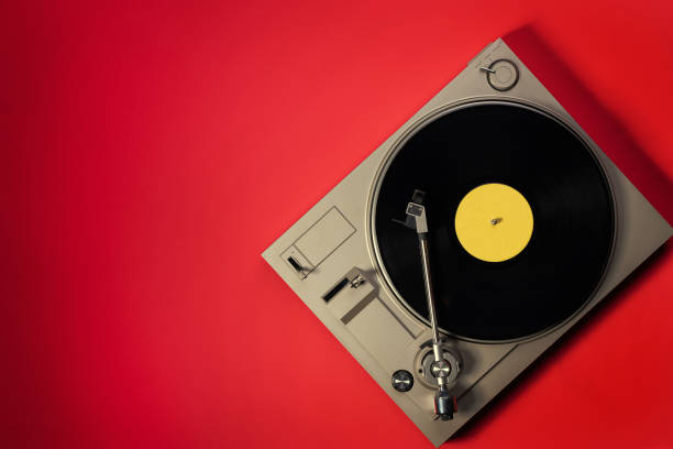 istock Gramophone with a vinyl record on a red table, top view and copy space,split toning for old style. 1358973316