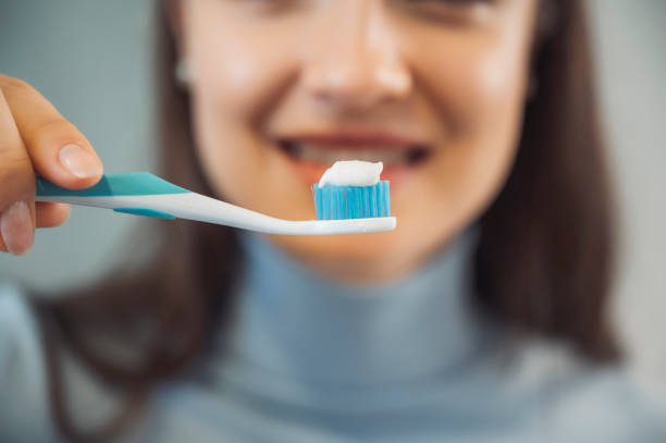 istock Young woman holding a toothbrush with toothpaste on 1358973627