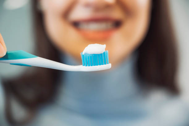 istock Young woman holding a toothbrush with toothpaste on 1358973629