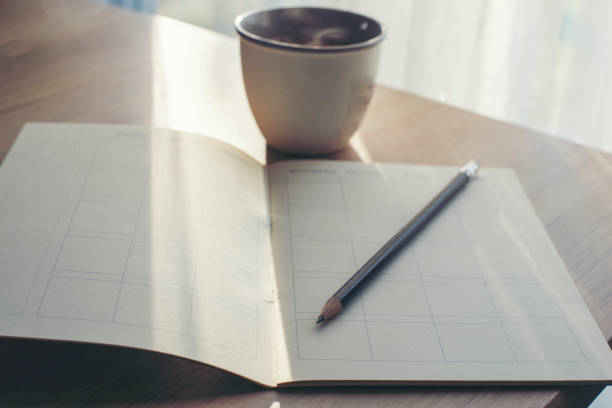 istock Diary, Calendar and agenda for Event Planner to plan timetable, appointment, organization, management on office table. Book, pencil, and coffee place on wooden desk. Calendar Background Concept 1358973871