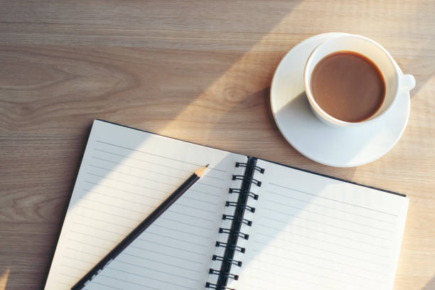 istock Diary, Calendar and agenda for Event Planner to plan timetable, appointment, organization, management on office table. Book, pencil, and coffee place on wooden desk. Calendar Background Concept 1358974556