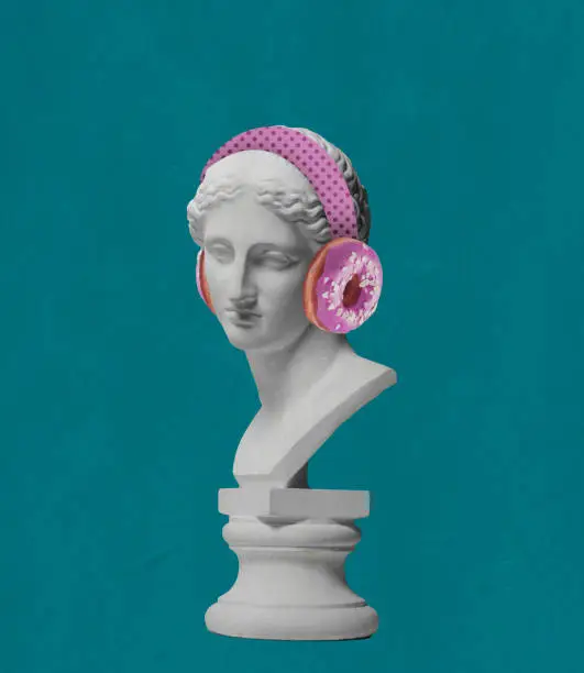 Contemporary art collage antique statue bust in modern pink headphones with donut element isolated over green background. Concept of art, music, creativity, imagination. Copy space for ad