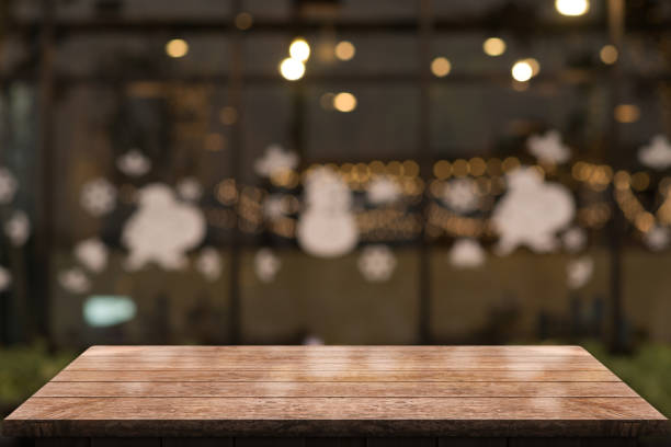 istock Empty wooden tabletop with lights bokeh on blur restaurant background. 1358979168