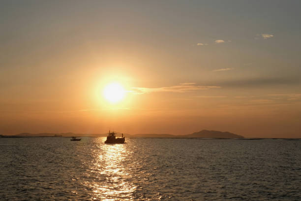 istock small boat floating on the sea at sunset 1358979460