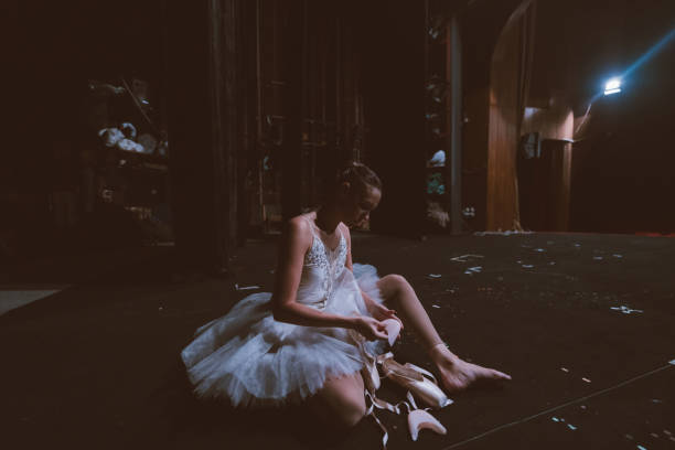 istock Ballet dancer tying her ballet shoe 1358980321