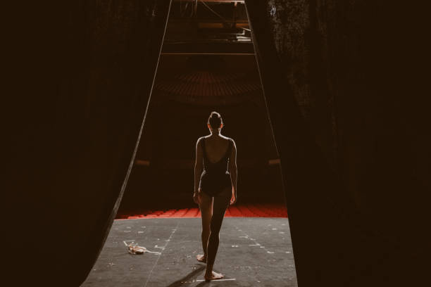 Rehearsal day Photo of a ballerina rehearsing alone on the stage of a theater. performance anxiety stock pictures, royalty-free photos & images