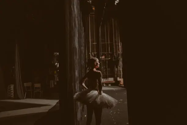 Photo of a ballerina backstage, waiting for the show to begin and anticipating her performance.