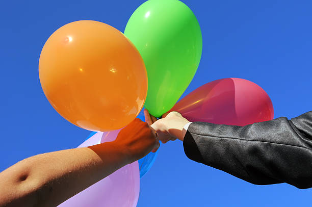 istock two men holding hands with multicolored balloons 135898335