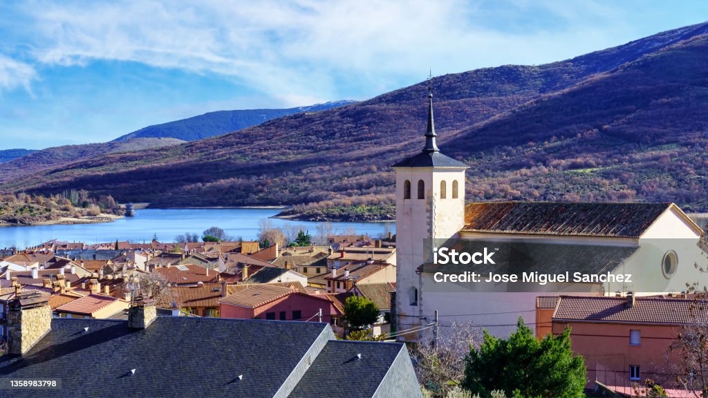 Old church with bell tower in an old village in the green valley of high mountains. Lozoya Spain. Madrid Stock Photo