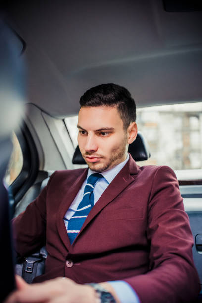 istock Urban businessman using a lap top in car 1358987482