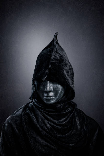 istock Scary figure with hooded cloak in the dark 1358988091