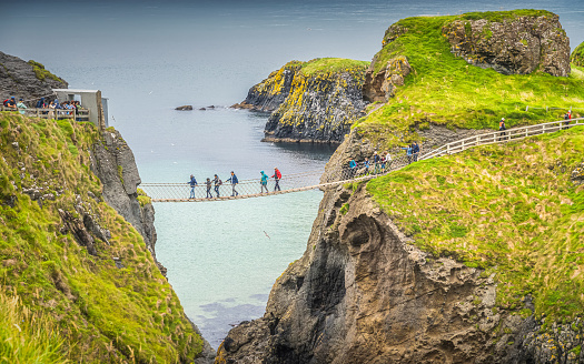 Ballycastle, August 2019 Closeup on people on the Carrick a Rede rope bridge and scenic island surrounded by turquoise Atlantic Ocean, Wild Atlantic Way, Northern Ireland