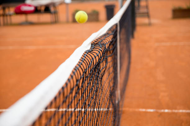 Tennis ball in the net at a clay court.