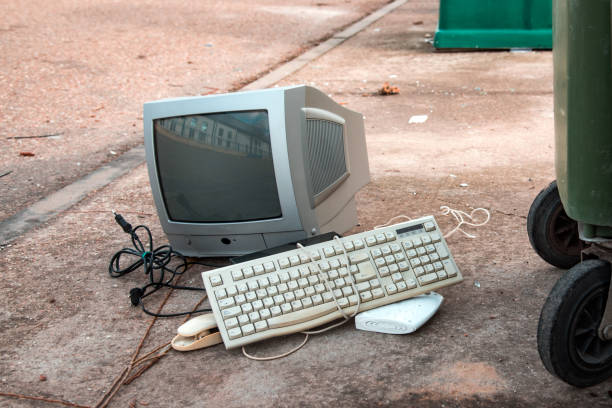 Broken computer on a concrete platform against a brick wall
