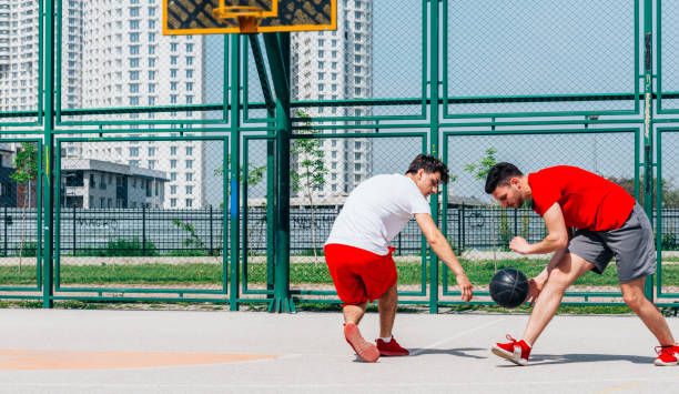 match de basket-ball. jouer au ballon avec un ballon noir portant des couleurs rouge, gris et blanc. - building block photos et images de collection