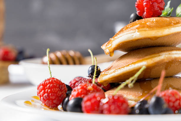 Fresh breakfast of punkake, berries and honey. Close-up