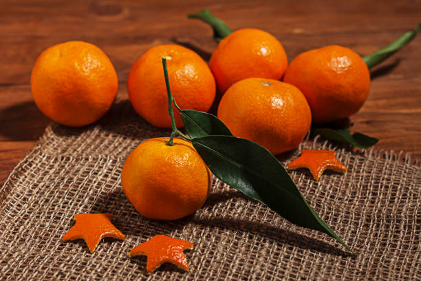 Fresh organic mandarins on rustic wooden table on home-woven canvas stock photo