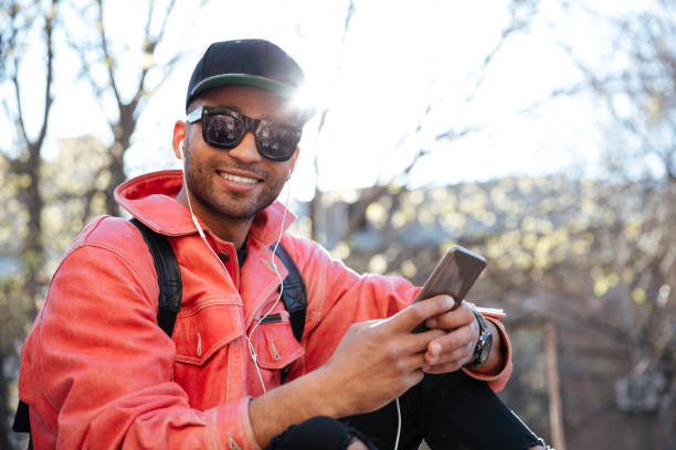 istock Young stylish afro american man in cap and leather jacket 1358994823