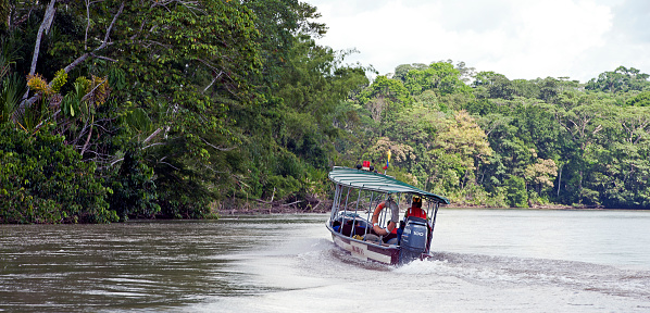 Water taxi at speed, Amazon River, Ecuador, South America. Ecuador a beautiful country with many Spanish colonial influences remaining, contains some of the most environmentally sensitive areas in the world, from the Amazon basin to the rain forest region, both of which are endangered through habitat loss, pollution and population pressures.